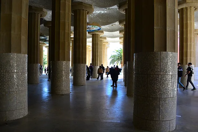 The Hypostyle Hall of Park Güell: a forest of tall Doric columns with tiled bases supporting the ceiling of the great terrace above